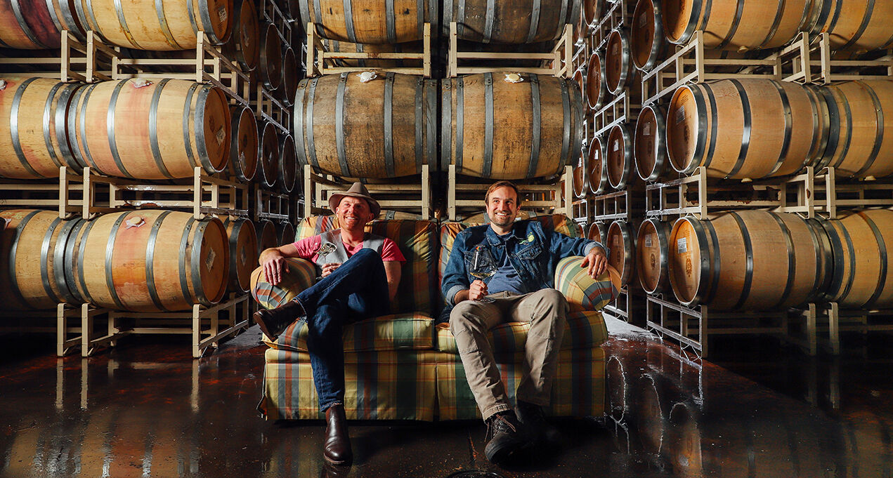 Gran Moraine Winemakers, Shane and Myles, sitting on a couch in the open-air winery.